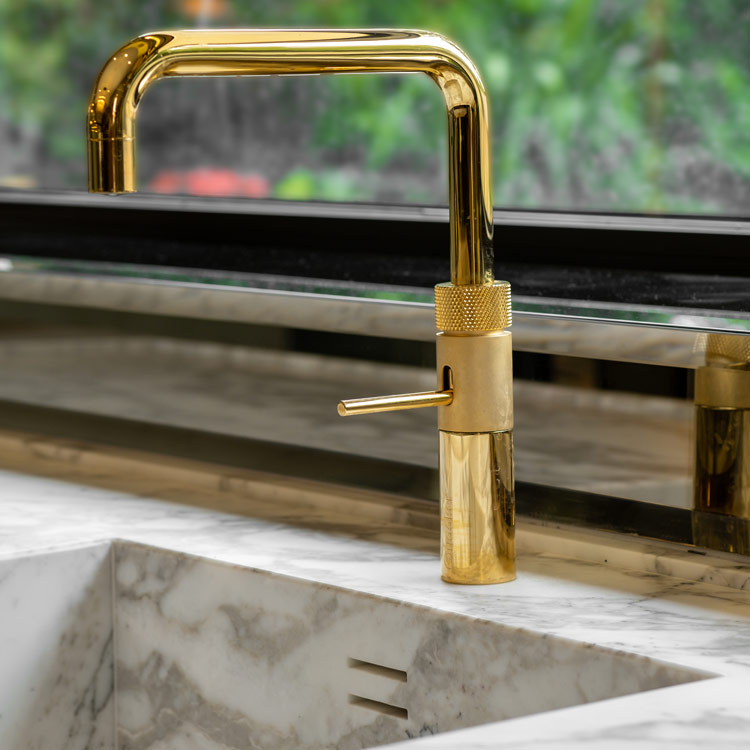 Gold tap over the stone sink in an Italian luxury kitchen by Fontana London | Design as Art